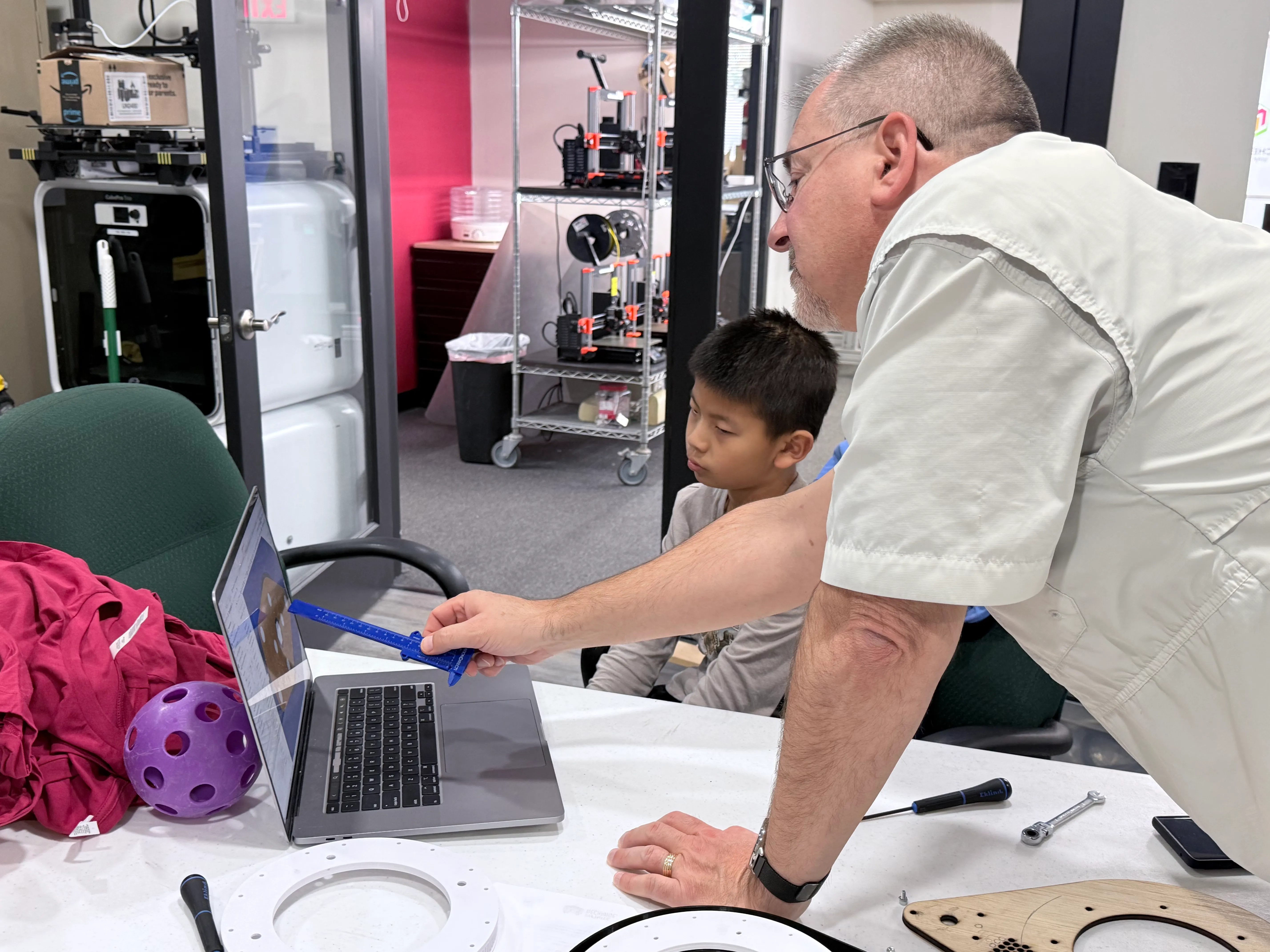 Mentor and student reviewing a design on a laptop