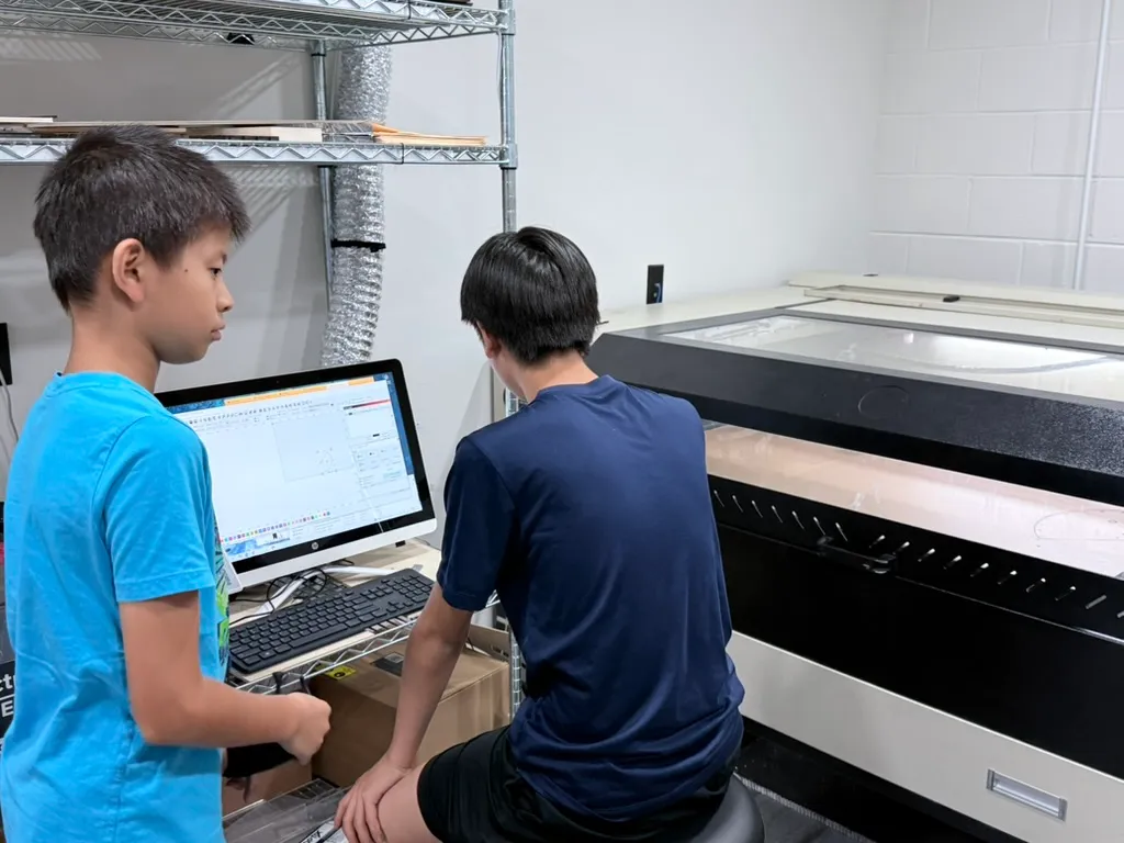 Students operating the CNC laser cutter at FutureForward