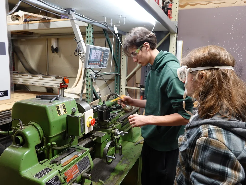 Students operating the manual lathe at FutureForward
